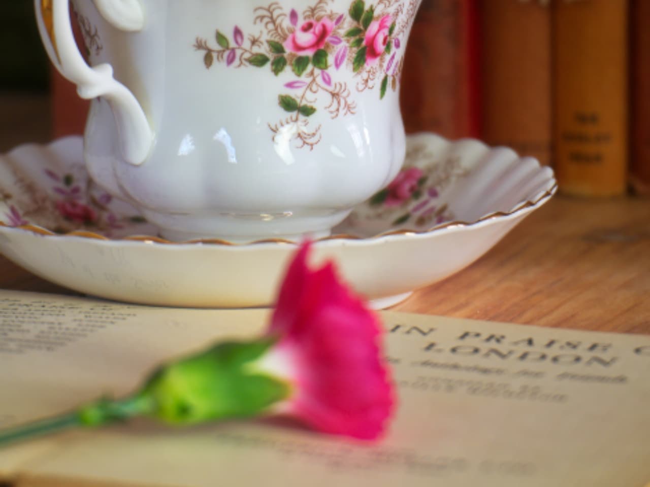 A teacup and saucer beside flowers
