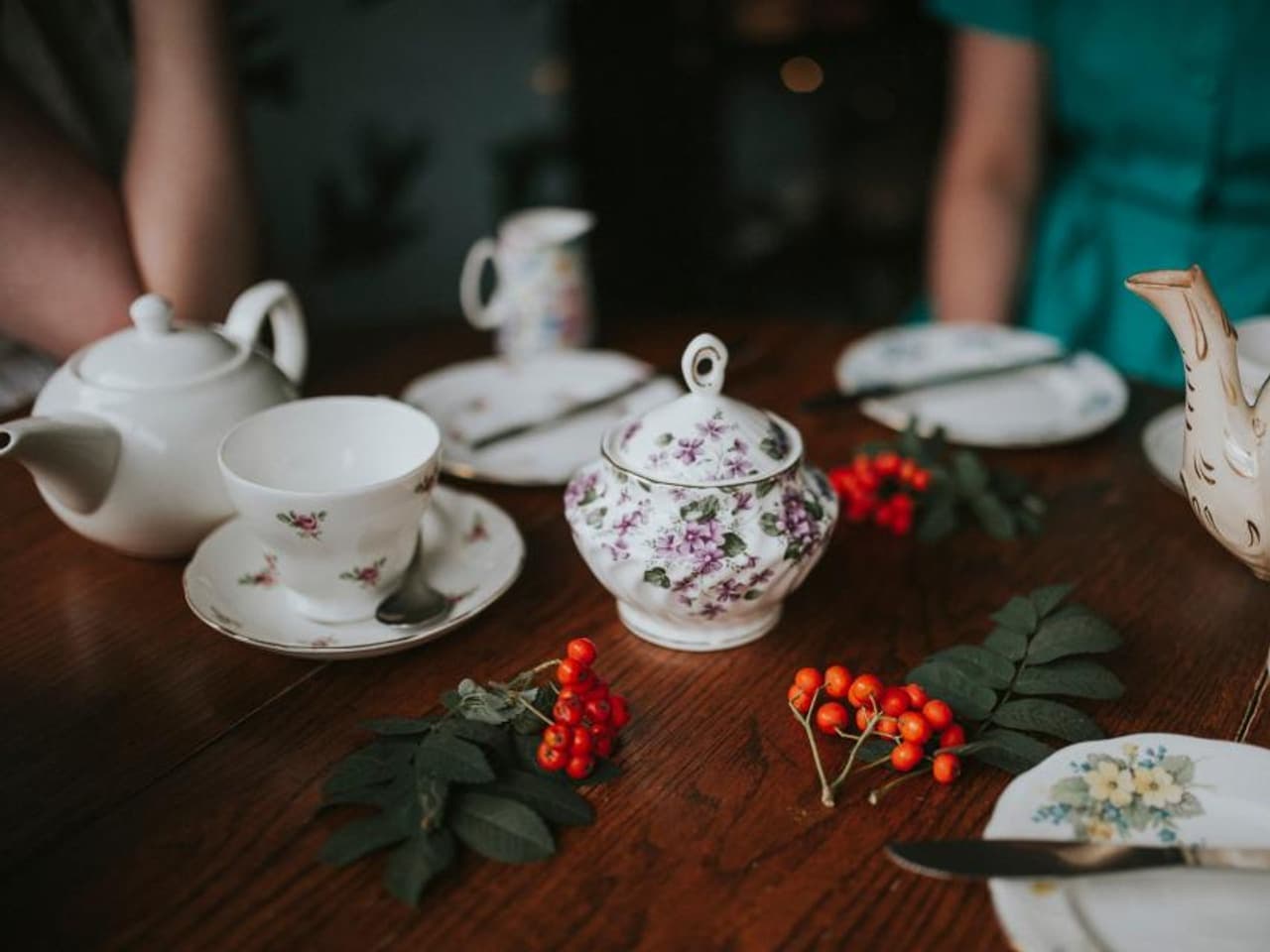 A teapot and cup with loose tea leaves