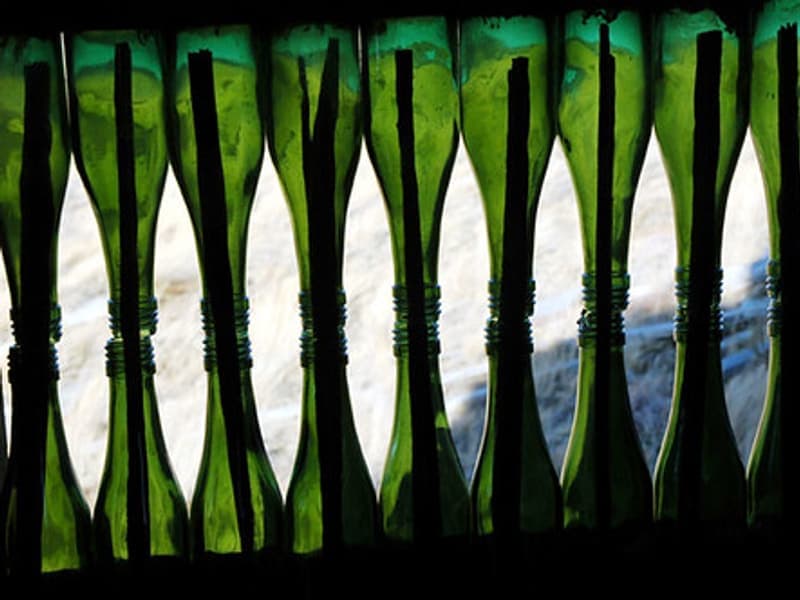 A wine bottle beside a glass in soft light