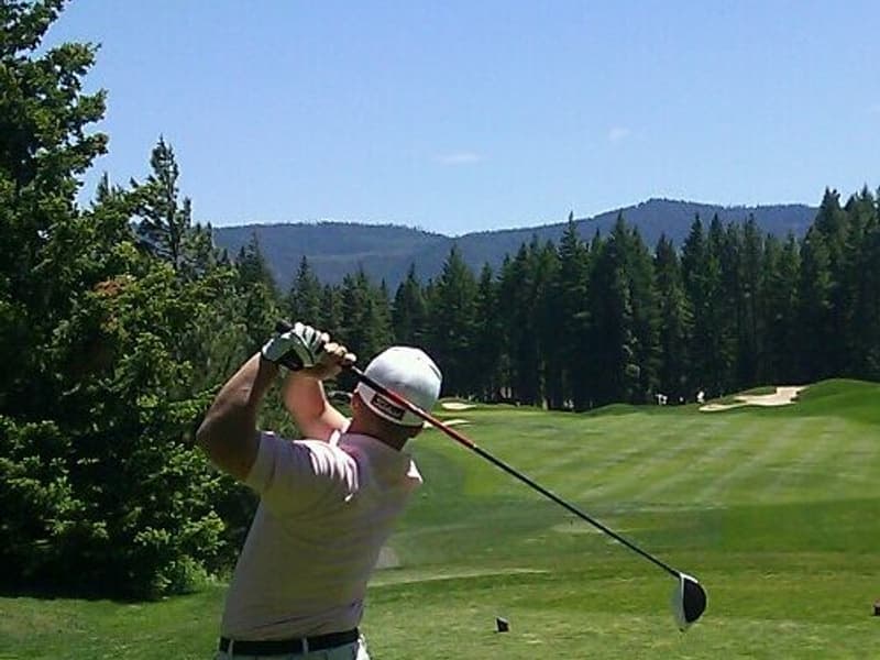 A golfer mid-swing on a course
