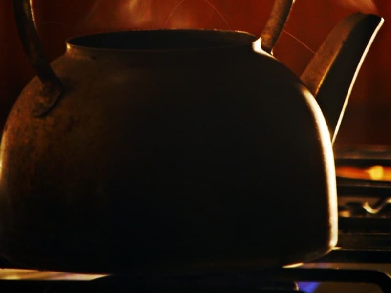 An electric kettle beside a teacup